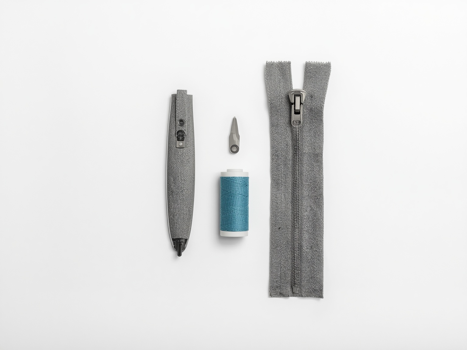 A garment zip laid out beside a replacement zip, thread and unpicker